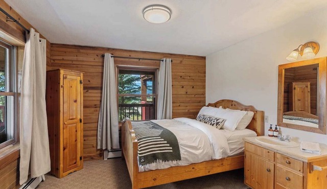Comfortable private queen room in the True North Adventure Lodge. Includes a queen bed, private ensuite bathroom, and access to shared amenities like the kitchen, great room, and hot tub. Great for couples or solo travelers.